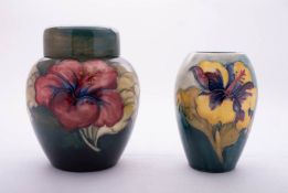 Two pieces of Walter Moorcroft pottery both tube lined in the Hibiscus pattern reserved on a