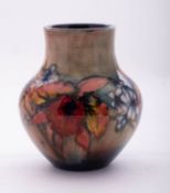 A William Moorcroft pottery vase of squat globular form tube lined in the Orchid pattern on a