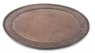 A large Middle Eastern silvered copper repoussé oval tray decorated with bands of stylised foliage,