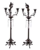 A pair of French patinated bronze three light candelabra,