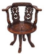 A late 19th Century carved dark oak revolving desk armchair,