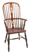 An elm seated Windsor chair, an arched spindle back with shaped and pierced central splat,
