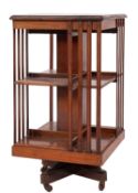 An Edwardian walnut square revolving bookcase with moulded top and slatted sides,