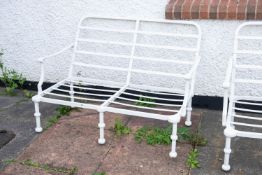 A pair of cream painted metal garden settees, with low table en suite,