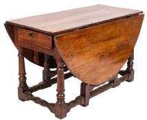 An oak gateleg dining table, late 17th century; with oval hinged top, on turned underframing,