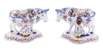 A pair of Dutch polychrome delftware milking groups each modelled with a cow standing four square