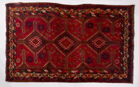 A Lori rug, the brick red field with triple stepped and pointed lozenge medallions,