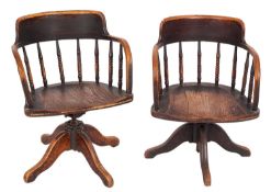 Two similar Edwardian elm and ash revolving office armchairs,