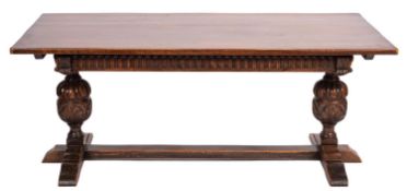 An oak dining table of refectory type, having a plain rectangular top and fluted frieze,