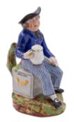 An early 19th century pearlware 'American Sailor' toby jug wearing a blue uniform with striped