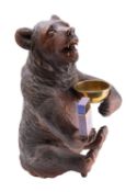 A 'Black Forest' carved and stained wood musical smokers' compendium in form of a bear,