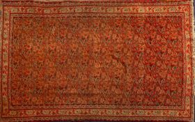 A Malayer rug, the brick red field with an all over boteh and geometric design,