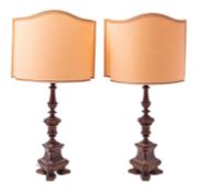 A pair of carved and stained walnut table lamps in the manner of Italian 17th century altar sticks;