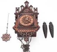 An oak cased late-19th century cuckoo wall clock the chain-driven movement striking the hours on a
