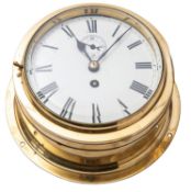 An Edwardian round brass bulkhead clock having an eight-day duration movement with a platform lever