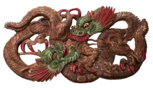 A large Chinese carved and polychrome wood carving in the form of two opposing dragons, 50 x 102cm.