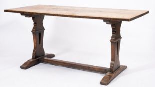 An oak trestle table, late 19th Century; the rectangular top on shaped bearers,