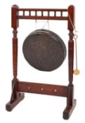 An Edwardian dinner gong and hammer, with a walnut frame with turned and ringed supports, 89 x 54cm.