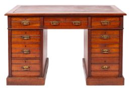 An Edwardian walnut pedestal desk, the moulded top inset with a simulated leather panel,