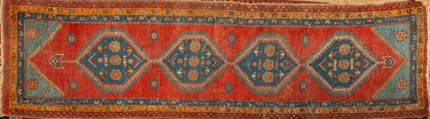 A Kurdish runner, the rose field with four pastel blue hexagonal hooked pole medallions,