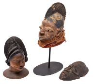 A carved and partially painted wood headdress 'Egungun' in the form of a woman's head,