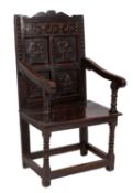 A 17th Century oak Wainscoat armchair, the back with shaped cresting,