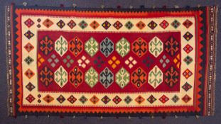 A Qashgai kelim, the wine field with two rows of stepped hexagonal medallions and geometric designs,