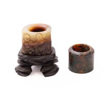 A Chinese carved jade archer's ring and an agate archer's ring the first of celadon and russet