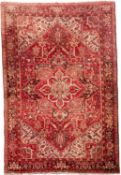 A Heriz carpet, the brick red field with a large geometric flowerhead pole medallion,