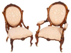 A Victorian Gentleman's armchair and lady's carved walnut matching chair,