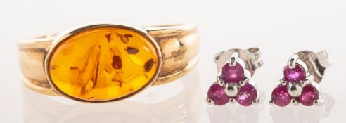 A dress ring and a pair of stud earrings, a 9ct gold ring set with an oval amber cabochon,