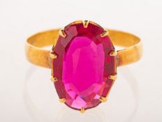 A dress ring, claw set with an oval-cut synthetic ruby, unmarked yellow metal, size K1/2, 2.0grams.