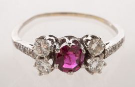A diamond and ruby ring, claw set to the centre with a circular-cut ruby, (damaged/cracked),