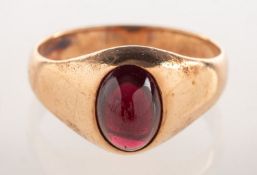 A garnet cabochon ring, collet set with an oval garnet cabochon, measuring approx. 8.7mm x 6.