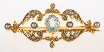 A Victorian aquamarine and seed pearl brooch, an ornately designed openwork brooch,