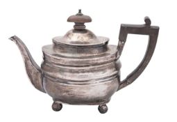 A George III silver tea pot, rounded oblong form, with an angular handle and on bun feet,