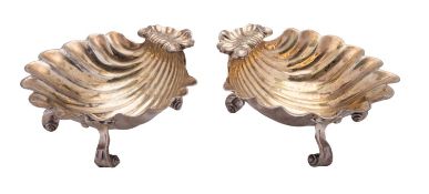 A pair of George III scallop shell silver salts, on three scroll legs and with gilt interiors,