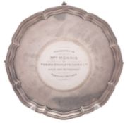 A George V silver salver, of shaped circular outline, with a moulded border and on ball & claw legs,