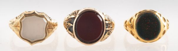 A group of three stone set signet rings, including a signet ring with an oval plaque of bloodstone,