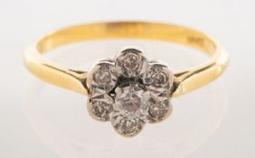 A diamond daisy ring, raised claw set to the centre with a brilliant-cut diamond, diamond approx. 0.