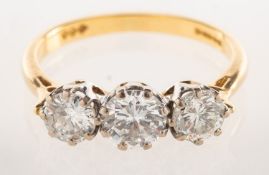 A 1980's 18ct gold three stone diamond ring, claw set with three brilliant-cut diamonds,