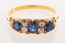 A Victorian sapphire and diamond ring, claw set with three oval-cut sapphires,
