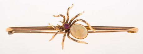 An early 20th century opal and ruby spider brooch, a bar brooch set centrally with a spider,