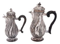 A near pair of late 18th/ early 19th century graduated German silver jugs, of baluster form,