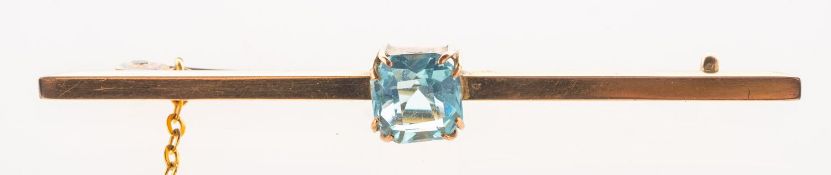 A bar brooch, claw set to the centre with a square-cut blue paste stone, metal pin, safety chain,