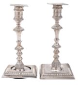 A pair of late Victorian silver candlesticks (A/F), on square bases (loaded),