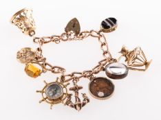 A charm bracelet with charms, a 9ct gold charm bracelet with heart padlock and safety chain,