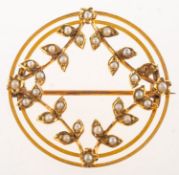 An Edwardian seed pearl brooch, a circular openwork brooch with a foliate design,
