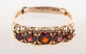 A 9ct gold five stone gypsy ring, claw set with five graduated circular-cut garnets,