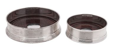 A graduated pair of modern silver mounted wooden wine coasters, circular outline,